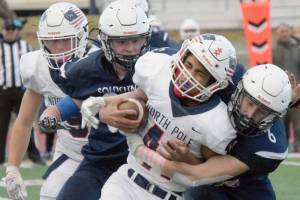 Soldotna's Jeren Nash and Wayne Mellon combine to bring down Via Skipps of North Pole on Friday, Oct. 8, 2021, at Justin Maile Field in Soldotna, Alaska. (Photo by Jeff Helminiak/Peninsula Clarion)