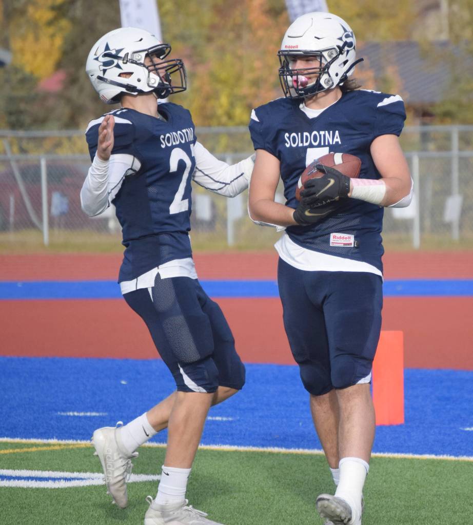 Brayden Taylor and Brock Wilson celebrate Wilsons touchdown run Friday, Oct. 8, 2021, at Justin Maile Field in Soldotna, Alaska. (Photo by Jeff Helminiak/Peninsula Clarion)
