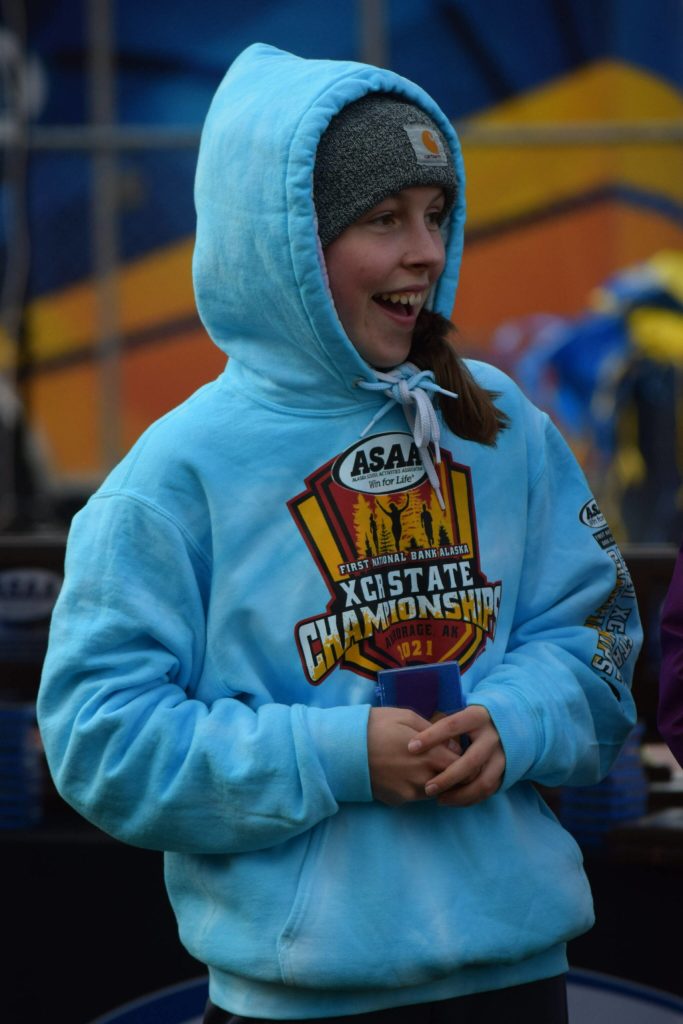 Eryn Field of Homer gets a medal at the Division II state cross country championship at Bartlett High School in Anchorage, Alaska on Saturday, Oct. 9, 2021 for her seventh place finish. (Camille Botello/Peninsula Clarion)