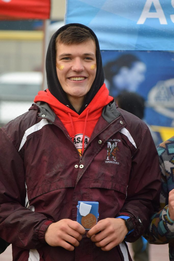 Justin Trail of Nikolaevsk gets a medal at the Division III state cross country championship at Bartlett High School in Anchorage, Alaska on Saturday, Oct. 9, 2021 for his third place finish. (Camille Botello/Peninsula Clarion)