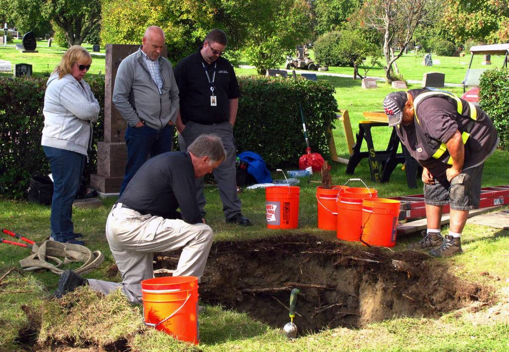 In this Sept. 3, 2014, file photo, workers and medical examiner crew members exhume the body of Jane Doe #3 from a cemetery in Anchorage, Alaska. The remains of a woman known for 37 years only as Horseshoe Harriet, one of 17 victims of a notorious Alaska serial killer, have been identified through DNA profiling as Robin Pelkey, authorities said Friday, Oct. 22, 2021. (AP Photo/Rachel DOro, File)