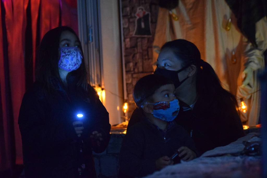 Heather and Hunter Phillips walk through the Kenai Community Library Haunted Hunt with their mom Kumi Phillips on Tuesday, Oct. 26, 2021. (Camille Botello/Peninsula Clarion)