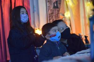 Heather and Hunter Phillips walk through the Kenai Community Library Haunted Hunt with their mom Kumi Phillips on Tuesday, Oct. 26, 2021. (Camille Botello/Peninsula Clarion)