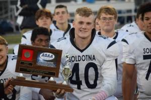 Soldotna senior Dylan Dahlgren accepts the teams runner-up award after the Division II state football championship game against Lathrop at Service High School in Anchorage on Saturday, Oct. 16, 2021.(Camille Botello/Peninsula Clarion)