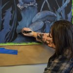 Abbey Ulen works on her installation for the Kenai Art Centers collaborative mural project on Wednesday, Nov. 3, 2021. (Camille Botello/Peninsula Clarion)