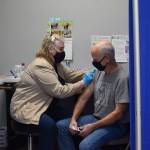 Nurse Linda Price gives Jim Blanning his Moderna COVID-19 booster shot at the Y intersection vaccine clinic on Thursday, Nov. 4, 2021. (Camille Botello/Peninsula Clarion)