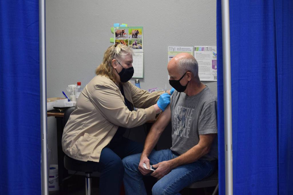 Nurse Linda Price gives Jim Blanning his Moderna COVID-19 booster shot at the Y intersection vaccine clinic on Thursday, Nov. 4, 2021. (Camille Botello/Peninsula Clarion)