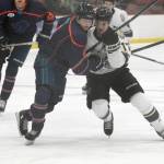 Anchorage Wolverines defenseman Danny Reis and Kenai River Brown Bears defenseman Carter Green battle for the puck Friday at the Soldotna Regional Sports Complex in Soldotna. (Photo by Jeff Helminiak/Peninsula Clarion)