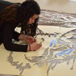 Tatihana DeHoyos cuts out the centerpiece stencil for the Kenai Alternative High Schools mural installation at the Kenai Art Center on Tuesday, Nov. 9, 2021. (Camille Botello/Peninsula Clarion)