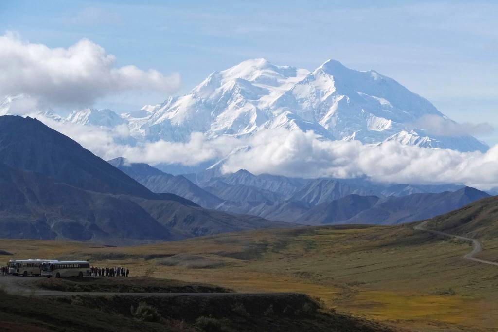 Sightseeing buses and tourists are seen at a pullout popular for taking in views of North Americas tallest peak, Denali, in Denali National Park and Preserve, Alaska, on Aug. 26, 2016. A Utah doctor is accused of lying to get a high-elevation helicopter to rescue him off the tallest mountain in North America and then destroying evidence. Dr. Jason Lance, who is a radiologist in Ogden, Utah, faces three misdemeanors, interfering with and violating the order of a government employee and for filing a false report from his May 2021, attempt to summit Denali, located about 180 miles north of Anchorage. (AP Photo/Becky Bohrer, File)