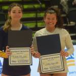 Homers Brooke Shafer and Kenais Valerie Villegas win the players of the match award at the end of the 3A state volleyball consolation game at the Alaska Airlines Center in Anchorage on Saturday, Nov. 13, 2021. (Camille Botello/Peninsula Clarion)
