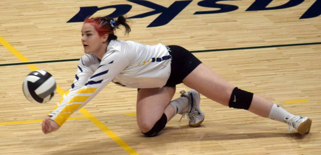 Homer libero Zoe Adkins dives for a ball during the Class 3A state volleyball consolation game at the Alaska Airlines Center in Anchorage, Alaska, on Saturday, Nov. 13, 2021. (Camille Botello/Peninsula Clarion)