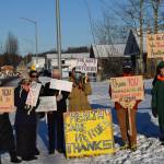 Members of the Many Voices advocacy group gather outside of Central Peninsula Hospital in Soldotna to demonstrate their support for healthcare staff on Saturday, Nov. 20, 2021. Folks protesting COVID-19 vaccine mandates and advocating for alternative treatments walk down the block behind them. (Camille Botello/Peninsula Clarion)