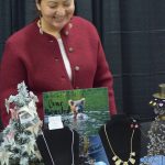 Michelle Ravenmoon sells salmon-bone earrings and other artisan products at the Soldotna Holiday Bazaar at the Soldotna Regional Sports Complex on Saturday, Nov. 20, 2021. (Camille Botello/Peninsula Clarion)