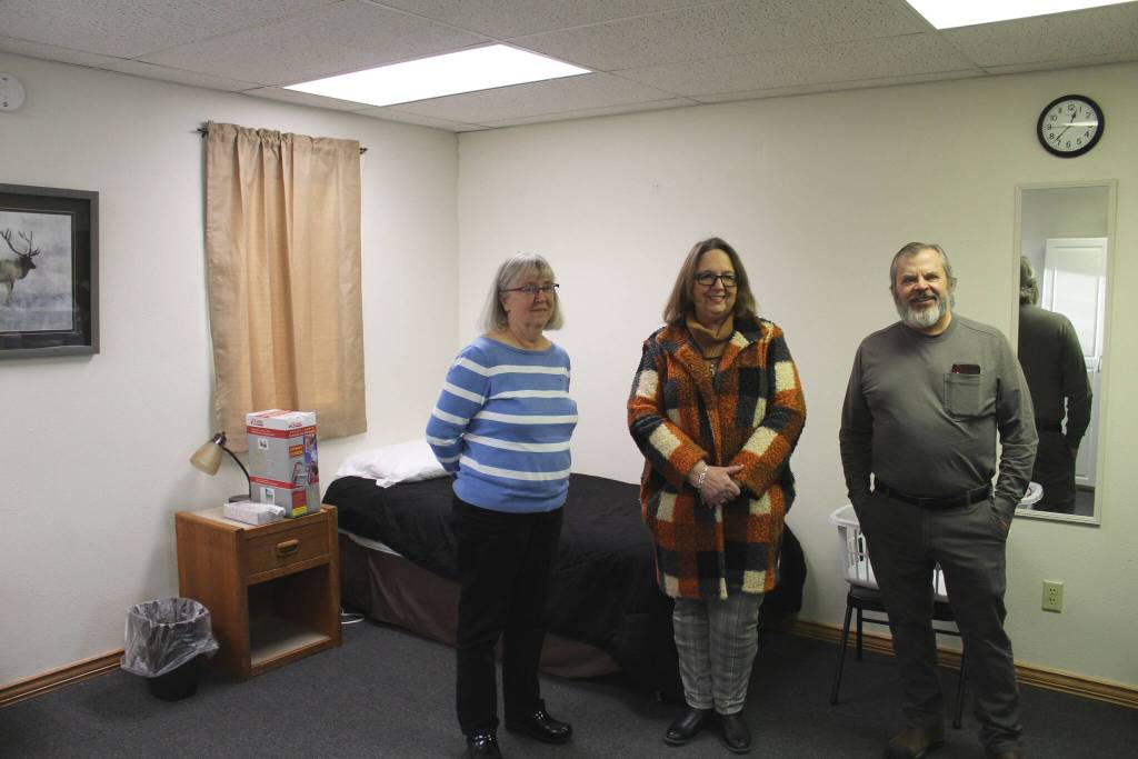 From left: Kathy Gensel, president of Bridges Community Resource Network, Inc.; Love INC Executive Director Leslie Rohr; and Tim Navarre, president of the Kenai Peninsula Foundation, stand in a bedroom at a cold weather shelter set to open next month on Monday, Nov. 22, 2021 in Nikiski, Alaska. (Ashlyn OHara/Peninsula Clarion)