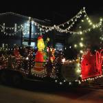 People sit on a float by Kendall Auto Group during the Christmas Comes to Kenai parade on Friday, Nov. 26, 2021 in Kenai, Alaska. (Ashlyn OHara/Peninsula Clarion)