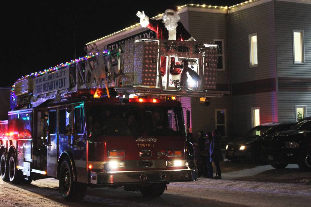 Santa Claus waves from the top of a Kenai Fire Department fire engine during the Christmas Comes to Kenai parade on Friday, Nov. 26, 2021 in Kenai, Alaska. (Ashlyn OHara/Peninsula Clarion)