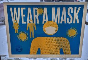 A sign urging COVID-19 mitigation measures hangs at a free vaccination clinic at the Y intersection of the Kenai Spur and Sterling highways, on Tuesday, Nov. 30 in Soldotna, Alaska. (Clarion file)