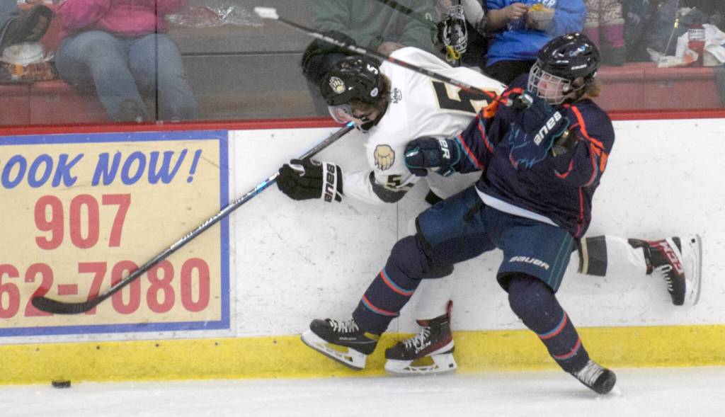 Nick Stevens of the Kenai River Brown Bears tries to squeeze by the check of Bohdan Panasenko of the Anchorage Wolverines on Friday, Dec. 3, 2021, at the Soldotna Regional Sports Complex in Soldotna, Alaska. (Photo by Jeff Helminiak/Peninsula Clarion)