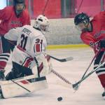 Kenai Central goalie Carson Koppes keeps Dylan Sowa of Juneau-Douglas from scoring Saturday, Dec. 4, 2021, at the Kenai Multi-Purpose Facility in Kenai, Alaska. (Photo by Jeff Helminiak/Peninsula Clarion)