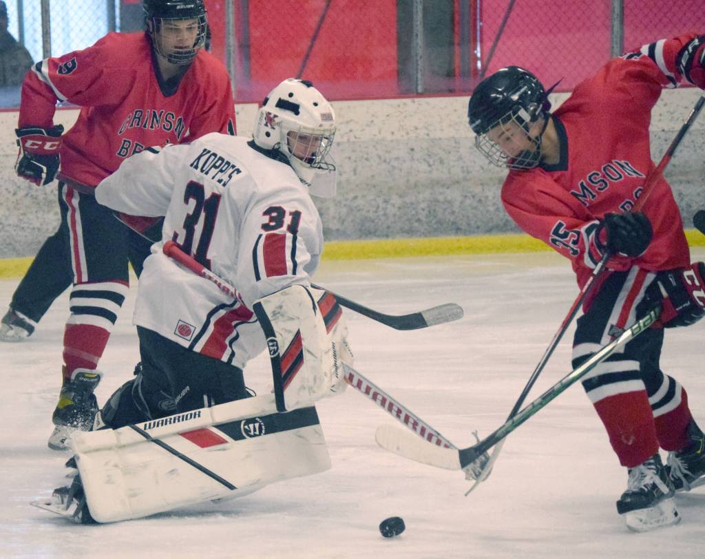 Kenai Central goalie Carson Koppes keeps Dylan Sowa of Juneau-Douglas from scoring Saturday, Dec. 4, 2021, at the Kenai Multi-Purpose Facility in Kenai, Alaska. (Photo by Jeff Helminiak/Peninsula Clarion)