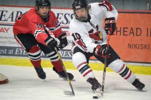 Kenai Central's Reagan Graves gets ready to score a goal while Camden Kovach defends Saturday, Dec. 4, 2021, at the Kenai Multi-Purpose Facility in Kenai, Alaska. (Photo by Jeff Helminiak/Peninsula Clarion)