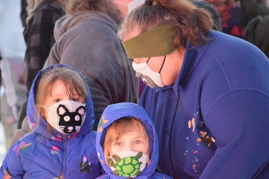 Teriany and Nakota Goff wait with their mom Teresa to take photos with Santa at Soldotna Creek Park on Saturday, Dec. 4, 2021. (Camille Botello/Peninsula Clarion)