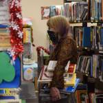 Junetta Delong browses the shelves at the Soldotna Library Friends book and art sale at the Soldotna Public Library on Saturday, Dec. 4, 2021. (Camille Botello/Peninsula Clarion)