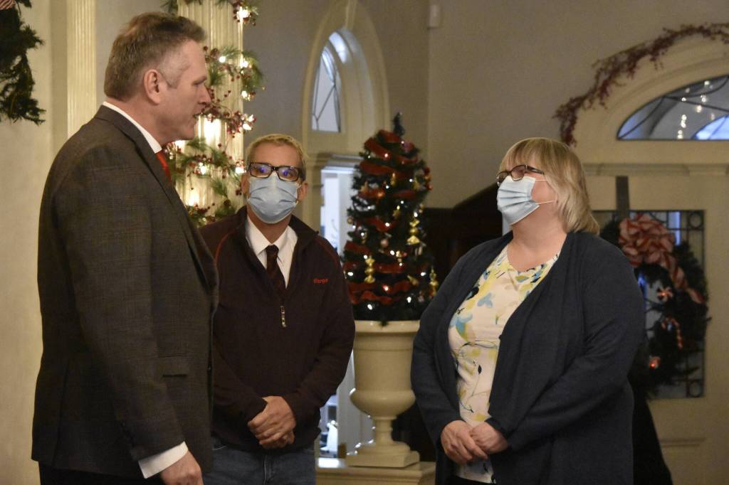Peter Segall / Capital City Weekly
Gov. Mike Dunleavy, left, meets with City and Borough of Juneau Mayor Beth Weldon, right, and City Manager Rorie Watt at a Christmas open house event Tuesday at the Alaska Governors Mansion.