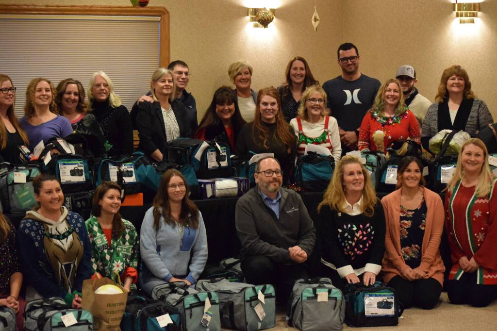 Members of the Kenai Peninsula Association of Realtors pose with donated holiday gifts for youth experiencing or at risk for experiencing homelessness during its annual award ceremony at Kenai Catering on Thursday, Dec. 9, 2021. (Camille Botello/Peninsula Clarion)