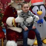 Brian Prather sits with Santa at the Nikiski Community Recreation Center on Saturday, Dec. 11, 2021, in Nikiski, Alaska. (Camille Botello/Peninsula Clarion)