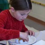 Adalynn Kouns makes a homemade gingerbread house at the Nikiski Community Recreation Center on Saturday, Dec. 11, 2021, in Nikiski, Alaska. (Camille Botello/Peninsula Clarion)