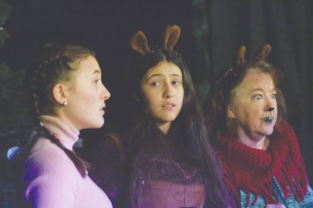 Sophia Micciche, Luci Micciche and Terri Burdick act as their characters during the Triumvirate Theater's rehearsal of "The Chronicles of Narnia: The Lioin, the Witch and the Wardrobe" at Kenai Central High School on Tuesday, Dec. 14, 2021. (Camille Botello/Peninsula Clarion)