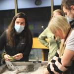 Kenai Watershed Forum Education Specialist Megan Pike, left, explains how rivers impact their surroundings during a demonstration given at the Donald E. Gilman River Center on Tuesday, Dec. 14, 2021 in Soldotna, Alaska. (Ashlyn OHara/Peninsula Clarion)