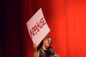 A cast member holds up a cue card in Soldotna High Schools production of "Annie" on Tuesday, Nov. 9, 2021. (Camille Botello/Peninsula Clarion)