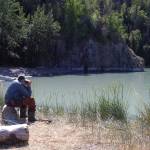 In this 2007 photograph taken on the former site of Cliff House, longtime area resident George Pollard uses binoculars to watch brown bears feed on salmon in Clear Creek. Pollard remembered watching bears from inside Cliff House for many years. (Clark Fair photo)