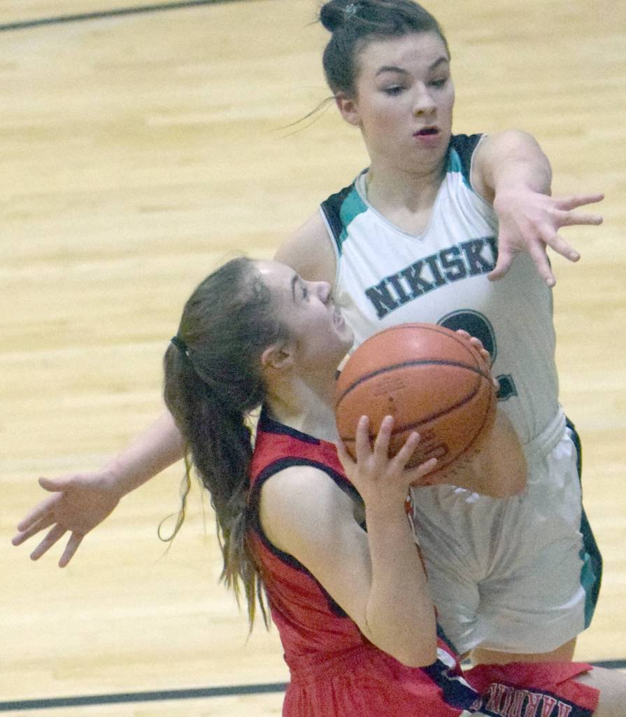 Kenai Centrals Sierra Hershberger shoots against Nikiskis Kinlee Jeffreys on Friday, Jan. 14, 2022, at Nikiski High School in Nikiski, Alaska. (Photo by Jeff Helminiak/Peninsula Clarion)