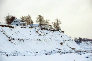 Camille Botello / Peninsula Clarion 
Buildings are perched above eroding bluffs on North Kenai Beach on Wednesday. The City of Kenai is receiving federal funds to address coastal erosion along sections of the bluff through the Infrastructure Investment and Jobs Act of 2021.