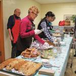 Volunteers distibute a meal to attendees at Project Homeless Connect on Jan. 29, 2020 at Homer United Methodist Church in Homer, Alaska. The event is a one-day opportunity for the homeless to get access to necessary supplies and services. (Photo by Megan Pacer/Homer News)