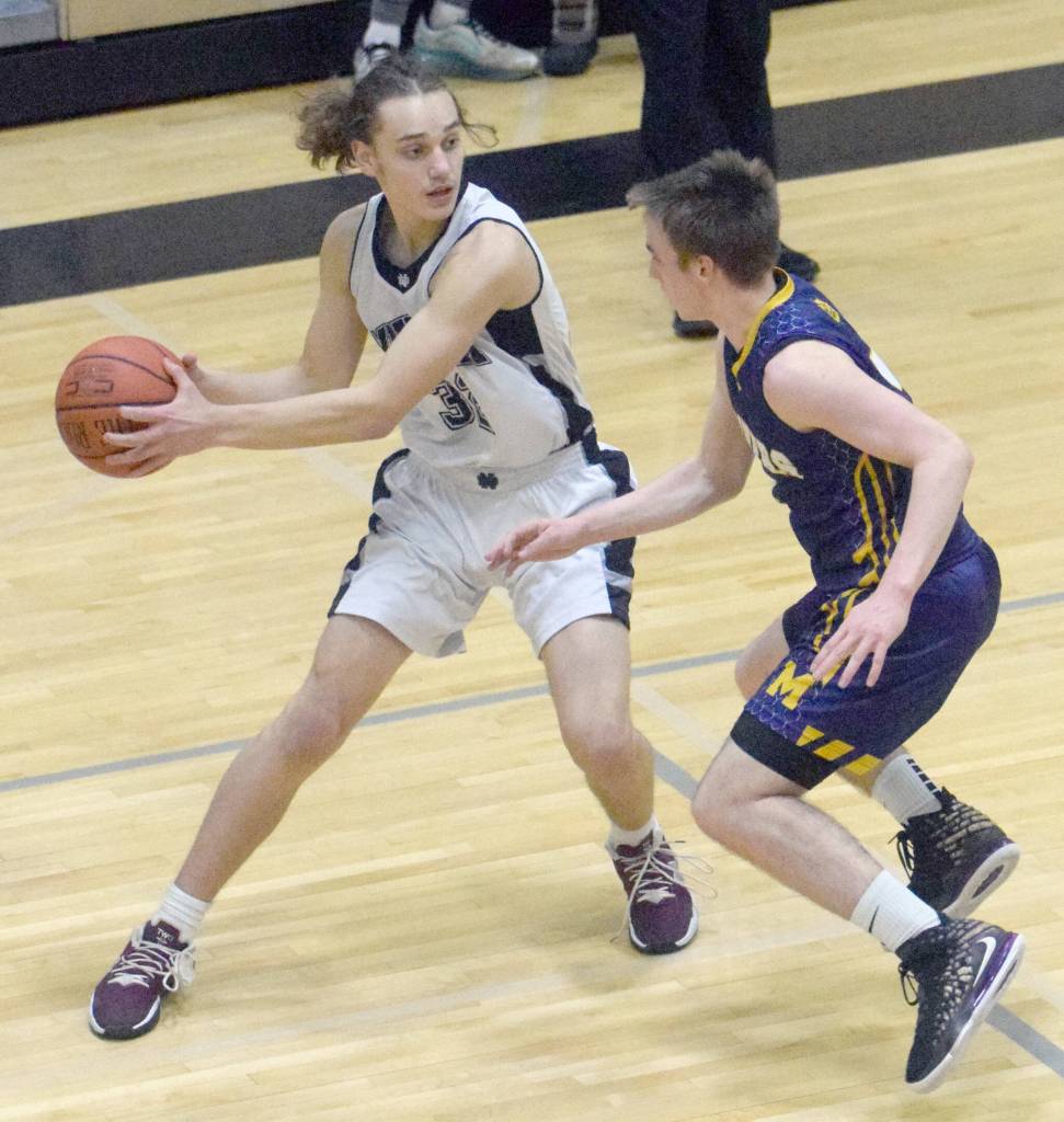 Nikiskis Seth Payne looks to pass under pressure from Homers Peyton Edens on Tuesday, Jan. 25, 2022, at Nikiski High School in Nikiski. (Photo by Jeff Helminiak/Peninsula Clarion)