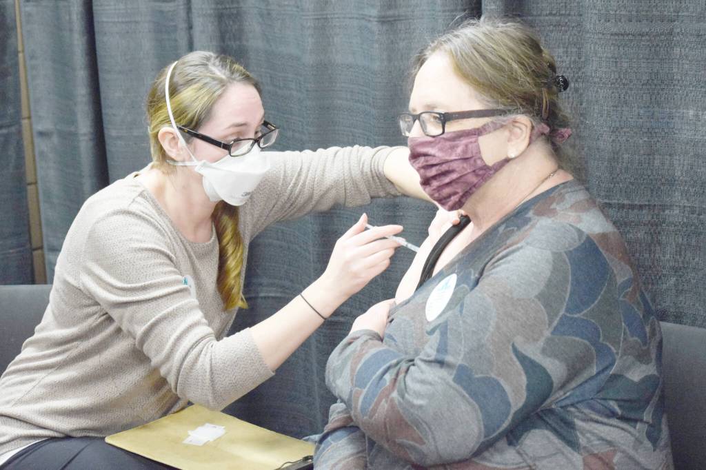 Kenai Public Health Nurse Sherra Pritchard gives Love Inc. Director Leslie Rohr a COVID-19 booster shot during the Project Homeless Connect event in Soldotna on Wednesday, Jan. 26, 2022. (Camille Botello/Peninsula Clarion)
