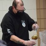 University of Alaska Anchorage human services intern Zachary Boyle serves lunch during the Project Homeless Connect event Soldotna Regional Sports Complex in Soldotna on Wednesday, Jan. 26, 2022. (Camille Botello/Peninsula Clarion)