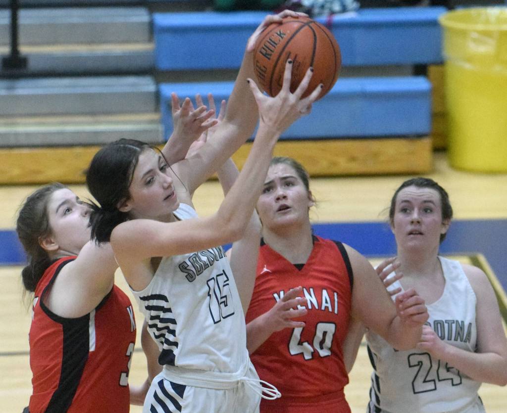 Soldotnas Adarra Hagelund grabs a rebound in front of Kenais Denali Bernard and Emma Beck, and SoHis Tanner Inman, at Soldotna High School on Friday, Jan. 28, 2022, in Soldotna, Alaska. (Photo by Jeff Helminiak/Peninsula Clarion)