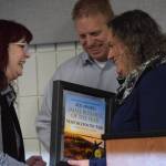 photos by Camille Botello / Peninsula Clarion 
Kimberly Hansen accepts the Soldotna Chamber of Commerces small business of the year award from Sara Hondel for her work at Northcountry Fair during the chambers 2021 award ceremony Wednesday at the Soldotna Regional Sports Complex.