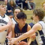 Kenai Central's Jakob Kvasnikoff tries to escape the trap of Nikiski's Drew Handley and Isaiah Daniels on Tuesday, Feb. 15, 2022, at Nikiski High School in Nikiski, Alaska. (Photo by Camille Botello/Peninsula Clarion)