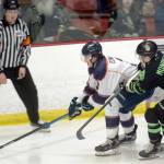 Anchorage Wolverines defenseman Ben Edwards shields the puck from Kenai River Brown Bears forward Bryce Monrean on Friday, Feb. 18, 2022, at the Soldotna Regional Sports Complex in Soldotna, Alaska. (Photo by Camille Botello/Peninsula Clarion)