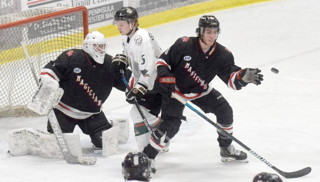 Kenai River Brown Bears forward Nick Stevens and Minnesota Magicians defenseman Evan Tanos battle for the puck in front of Minnesota Magicians goalie Josh Seeley on Friday, Feb. 25, 2022, at the Soldotna Regional Sports Complex in Soldotna, Alaska. (Photo by Jeff Helminiak/Peninsula Clarion)