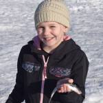 Aurora Borealis Charter School third grader Moriah Hodges poses with her catch of the day while ice fishing at Sport Lake as part of the Alaska Department of Fish and Games Salmon in the Classroom ice fishing educational program on Wednesday, March 2, 2022, in Soldotna. (Camille Botello/Peninsula Clarion)