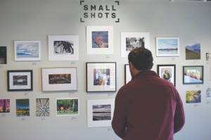 photos by Camille Botello/Peninsula Clarion 
Alex Rydlinski, executive director of the Kenai Art Center, sets up the Small to Biggs photography show at the Kenai Art Center on Wednesday,