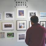 Alex Rydlinski, executive director of the Kenai Art Center, sets up the Small to Biggs photography show at the Kenai Art Center on Wednesday, March 2, 2022, in Kenai, Alaska. (Camille Botello/Peninsula Clarion)